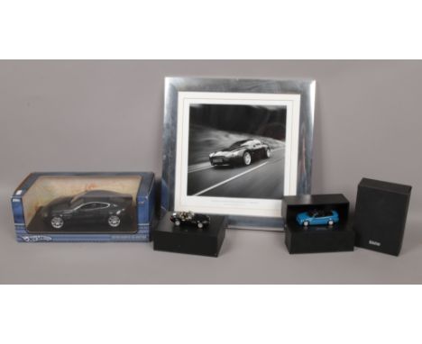 A boxed Hotwheels 1:18 scale Diecast model of an Aston Martin V8 Vantage, two boxed Diecast model BMW and a framed Aston Mart