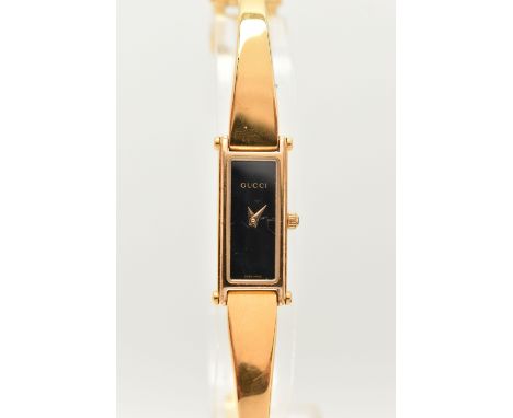 A LADIES 'GUCCI' WRISTWATCH, quartz movement, rectangular black dial, signed 'Gucci', gold plated case, approximate case widt