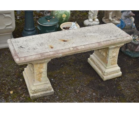 A WEATHERED COMPOSITE GARDEN BENCH, on twin bases, length 116cm x depth 39cm x height 48cm (condition report: two darker stai