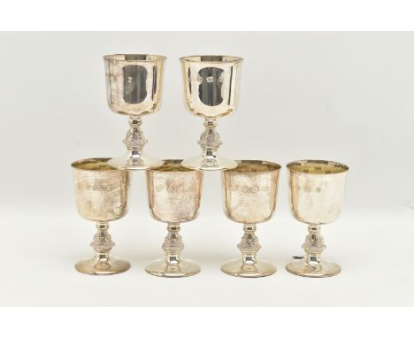 A SET OF SIX ELIZABETH II SILVER GOBLETS, the bucket shaped bowl with gilt interior, on stem cast with Celtic motifs, slightl