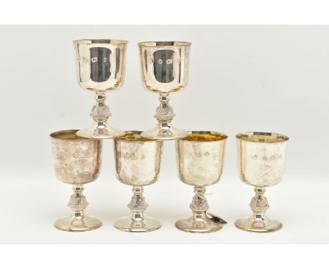 A SET OF SIX ELIZABETH II SILVER GOBLETS, the bucket shaped bowl with gilt interior, on stem cast with Celtic motifs, slightl