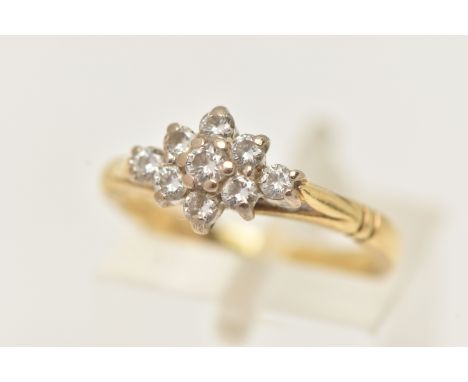 AN 18CT GOLD DIAMOND CLUSTER RING, nine round brilliant cut diamonds, prong set in white gold, leading on to a yellow gold sh