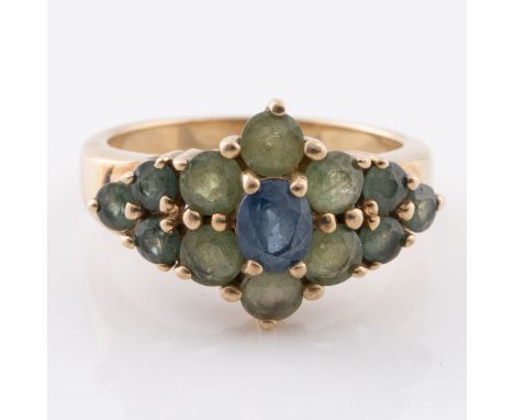 A 9ct gold ring with sapphire surrounded by jadeite within a graduated star pattern, size O½, total weight 4.8g. Fully hallma