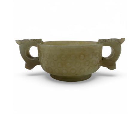 An early 20thC Chinese jade 'Rice Grain' pattern two-handled libation cup, based on an archaic bronze form, the body carved w