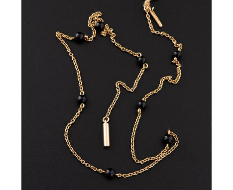 A 9ct gold and onyx necklace, the chain is divided into equal lengths by black beads (probably polished onyx), with barrel lo