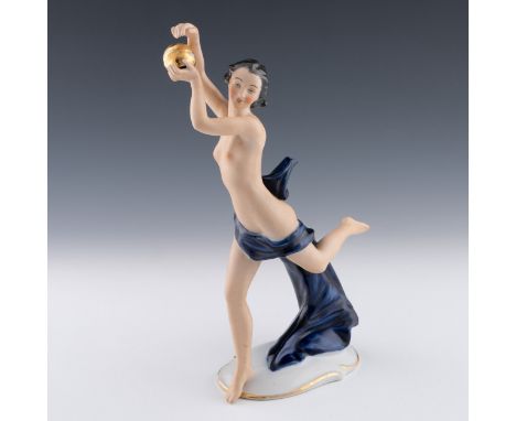 A Volkstedt pottery female figure, c.1900, the sculpture depicts a nude woman draped in blue cloth holding a golden orb, with