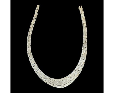 A solid white metal necklace with interlocking Aztec design and with safety clasp, impressed marks on the reverse including 9