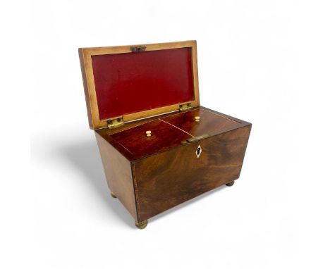A late Regency cross banded sarcophogus shaped tea caddy. Each of the panels is edged with four colour banding. Four ball bra