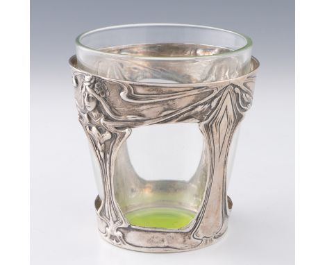 A German silver tumbler holder with replacement glass liner c.1910, with Jugendstil repousse decoration with ladies with flow