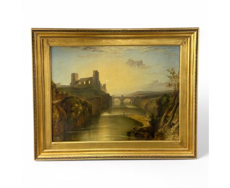 A 19thC probably British oil on canvas of a landscape at sunset with a ruined castle or abbey by a bridge over a river, with 