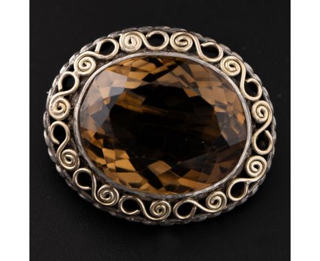 A silver and citrine brooch, the citrine is set within a double border with silver gilt decorative band set between the citri