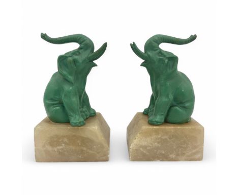 A pair of 1930s Art Deco elephant bookends, probably moulded in spelter, finished in light green paint, mounted on shaped mar
