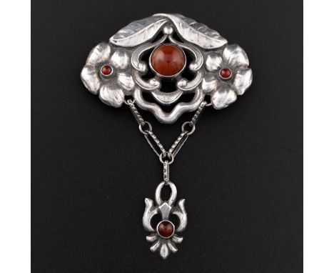 An Art Nouveau white metal pin or brooch, die-stamped and embossed in the form of stylised flowers and leaves, with pendant c