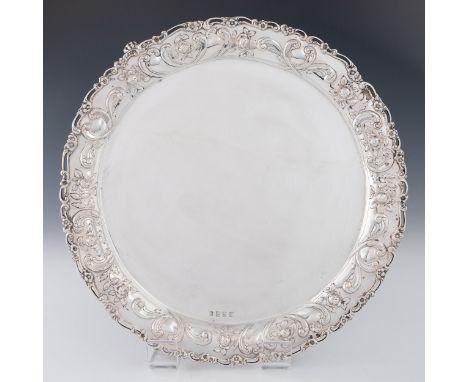 A sterling silver salver by Lawson & Co, Glasgow 1903, with elaborate pieced and floral repousse border with three cast scrol