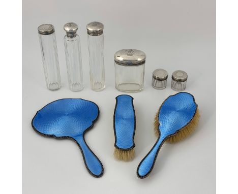 A group of Edwardian dressing table items, comprising six facet or slice cut colourless glass jars with silver lids, four eng