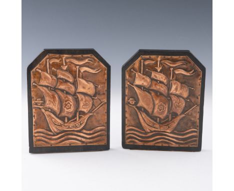 A pair of Arts & Crafts copper galleon bookends, c.1910, ebonised wood bookends depicting galleons in copper, 15.5cm height. 
