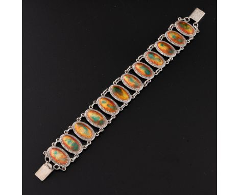 A silver and enamel bracelet c.1910, with twelve silver mounted orange and green enamel plaques, with silver surrounds interl