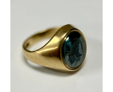 A 9ct gold gentleman's signet ring, set with an oval grey metal panel cut with the profile of a Roman soldier's head, with he