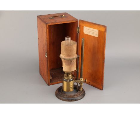 A Microscope Oil Lamp, on a cast iron base embossed ''JAMES HOW FOSTER LONDON' with brass support and bottle holder, with cer
