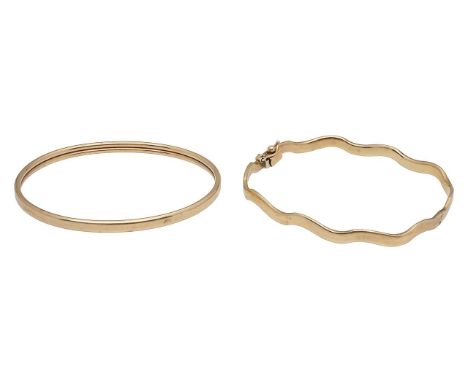 A 9ct gold pair of banglesincluding a wavy design hinged bangle, 9ct hallmark to catch and an oval plain bangle with a hidden