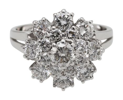 A diamond set cluster ringfeaturing a centre round brilliant cut diamond claw set, surrounded by eight brilliant cut diamonds