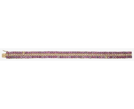 A ruby and diamond line braceletfeaturing two rows of fine round rubies either side of a single row of diamonds claw set to a