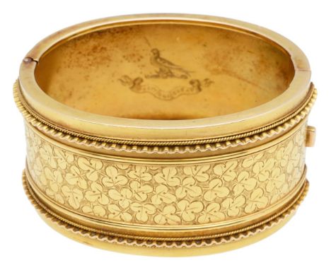 An attractive Victorian 15ct gold wide oval commemorative cuff banglethe top section hand engraved with three leaf clover pat