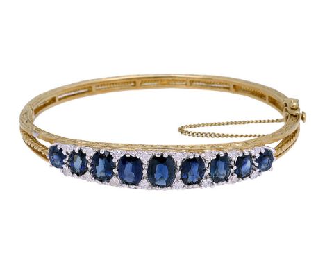 A Victorian style 9ct gold sapphire and diamond stiff bangle with graduated sapphires set with diamond points, marked on clas