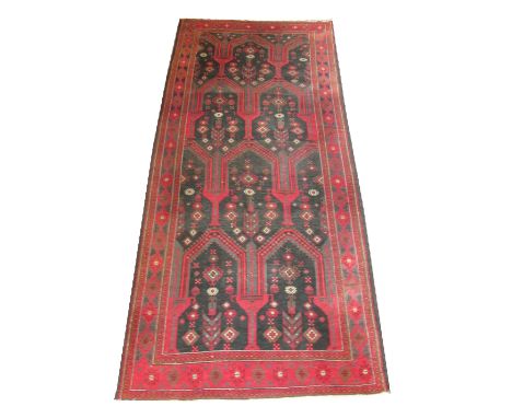 BALUCH KELLEH CARPET, 300cm x 135cm, stylised vases, vines and flowerheads on a noir field inside multiple geometric terracot