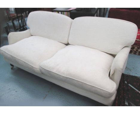 SOFA, Howard style, two seater, with cream upholstery on short turned front supports with castors, 189cm L. (with faults, a f