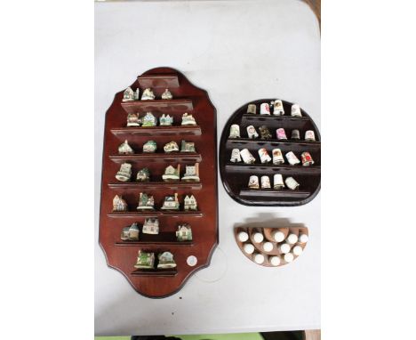 THREE WOODEN STANDS CONTAINING A QUANTITY OF MINIATURE CERAMIC HOUSES AND PORCELAIN THIMBLES
