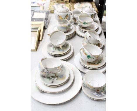 AN ORIENTAL TEASET WITH DRAGON DESIGN TO INCLUDE A TEAPOT, SUGAR BOWL, CREAM JUG, CUPS, SAUCERS AND SIDE PLATES