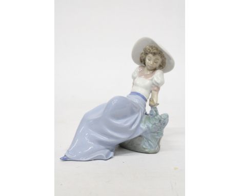 A NAO FIGURINE OF A GIRLSITTING ON A ROCK WITH A BIRD