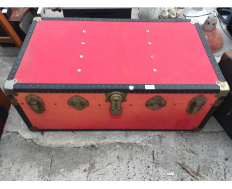 A RED COMPRERSSED FIBRE TRAVEL TRUNK