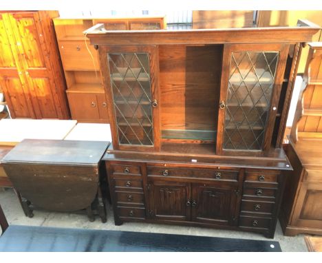 AN OAK GILBERTS HOUSE FURNISHERS DRESSER WITH GLAZED AND LEADED UPPER SLIDING CUPBOARD, PULL OUT SLIDE WITH CUPBOARDS AND DRA