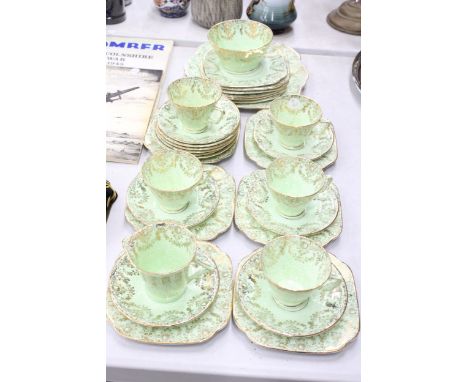 A VINTAGE GREEN AND GILT TEASET TO INCLUDE A CAKE PLATE, SUGAR BOWL, CREAM JUG, CUPS, SAUCERS AND SIDE PLATES