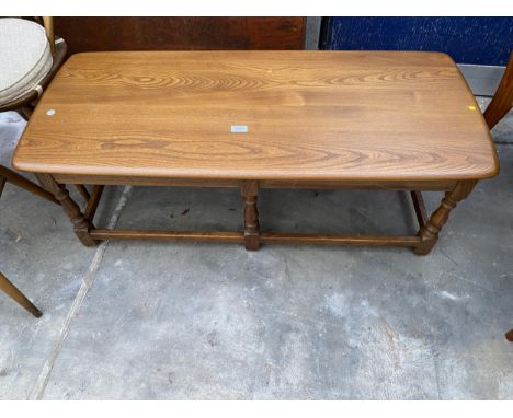 AN ERCOL ELM COFFEE TABLE ON SIX TURNED LEGS, 45" X 19"