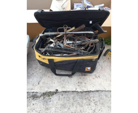 A TOOL BAG CONTAINING AN ASSORTMENT OF TOOLS TO INCLUDE SPANNERS, SAWS AND A RASP ETC