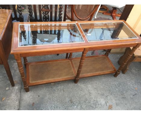 A HARDWOOD SIDE TABLE WITH INSET GLASS TOP AND CANE BASE SHELF, 51" X 17"