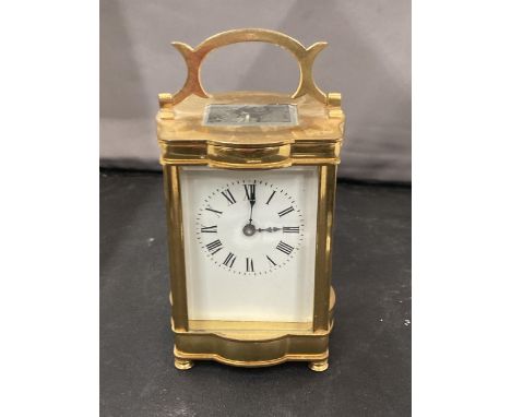 A BRASS CARRIAGE CLOCK WITH WHITE ENAMEL FACE, ROMAN NUMERALS AND VISUAL ESCAPEMENT