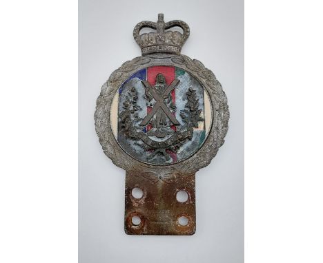A Vintage car badge with a military Cameron badge attached 