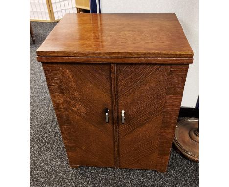 A Vintage Singer Sewing machine with cast iron pedal base, all fitted within an oak cabinet. 