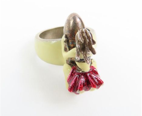 A silver and cold enamel novelty ring of a girl riding upon a bullet, 2005 