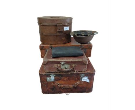 A WWI metal helmet, a painted metal hat box; a brown leather travelling case, a leather cased dressing set and two other case