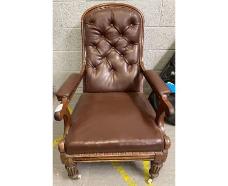 A Victorian mahogany framed gentleman’s chair with upholstered open arms and tapering fluted front supports with original cer