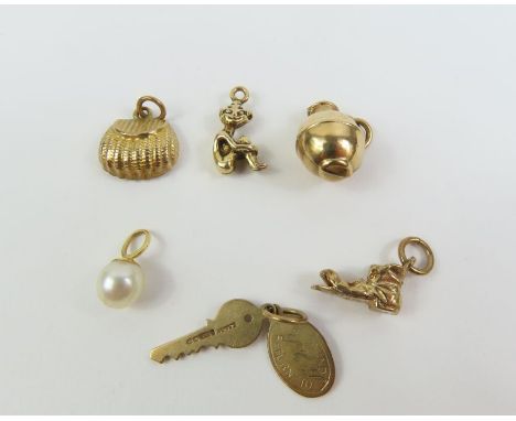 A collection of five charms, 5.6 grams gross and a cultured pearl pendant, marked '750'