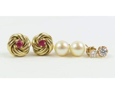 A pair of ruby set knot stud earrings, a pair of white stone set earrings, both testing as 9ct gold, 2.3g gross; and a pair o