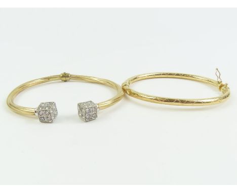 A torc style sprung bangle, with cube terminals set with stones, stamped ’375’; with a 9 carat gold sprung hinged bangle; 13.