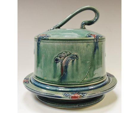 An A &amp; J Young, Norfolk studio pottery cheese cloche, footed base, decorated in relief with irises on a jade green ground