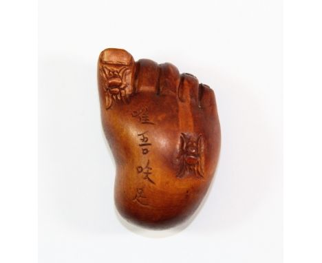 A carved fruitwood netsuke of the Buddha's foot, L 5.5cm